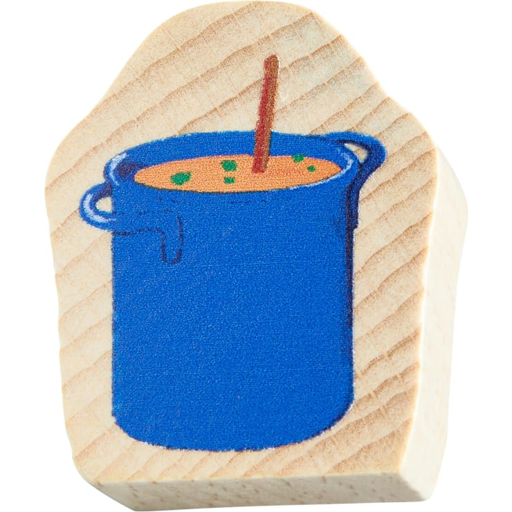Auf einem Holzblock ist ein blauer Topf mit orangefarbener Suppe abgebildet, garniert mit grünen Kräutern und einem braunen Löffel, der aus dem Topf ragt.