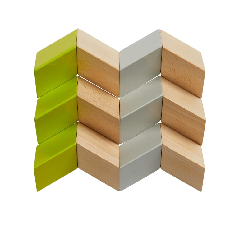 Vier Reihen von rechteckigen Holzblöcken sind in einem Zickzack-Muster angeordnet. Die Blöcke sind in den Farben Grün, Grau und Naturholz gehalten, mit Grün an einem Ende, Grau in der Mitte und Holz am anderen Ende.