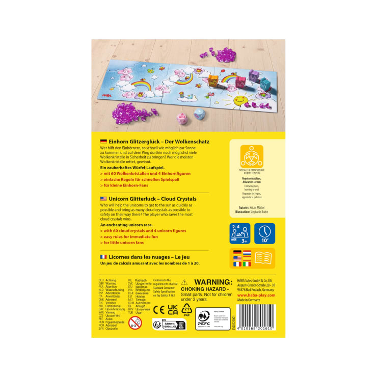 Die Rückseite einer Brettspielschachtel für Kinder zeigt einen Spielaufbau mit einem Spielbrett, Einhornfiguren, Wolken und Kristallen. Der Text beschreibt das Spiel auf Deutsch, Englisch und Französisch. Sicherheitshinweise und Altersempfehlungen sind sichtbar.