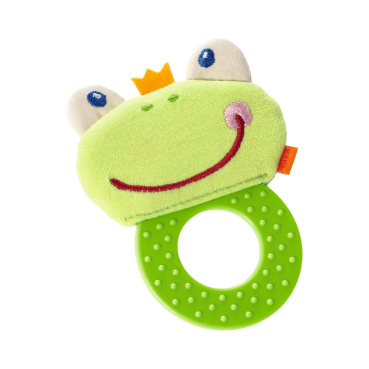 Ein grüner Beißring für Babys mit einem strukturierten, runden Griff und einem weichen Froschkopf mit zwei Augen, einem lächelnden Gesicht und einer kleinen gelben Krone auf der Oberseite.
