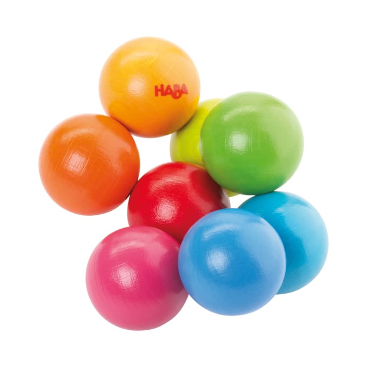 Acht Holzkugeln in verschiedenen Farben - orange, gelb, grün, blau, rot, rosa und türkis - sind zu einem Bündel zusammengefügt. Auf einer Kugel ist das Wort HABA aufgedruckt.