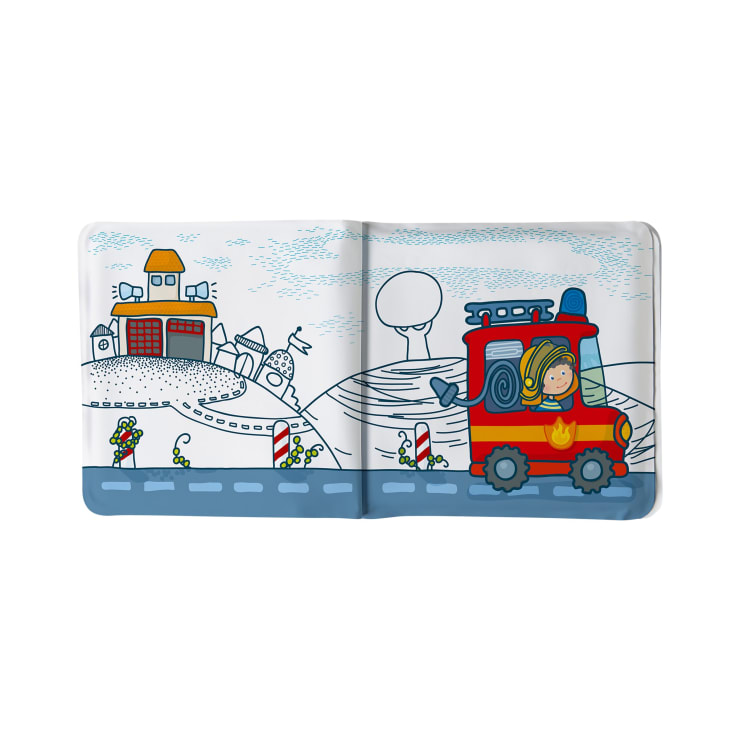 Illustration einer Kinderbuchseite, die ein Cartoon-Feuerwehrfahrzeug mit einem Feuerwehrmann zeigt, der auf einer Straße fährt, mit Gebäuden, Bäumen und Blumen im Hintergrund. Die Farben sind hauptsächlich rot, blau und weiß.
