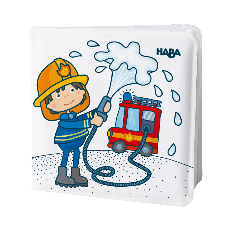 Ein Cartoon-Feuerwehrmann in Uniform und mit Helm spritzt Wasser aus einem Schlauch, mit einem roten Feuerwehrauto im Hintergrund. Das Wort HABA ist in der oberen rechten Ecke aufgedruckt.
