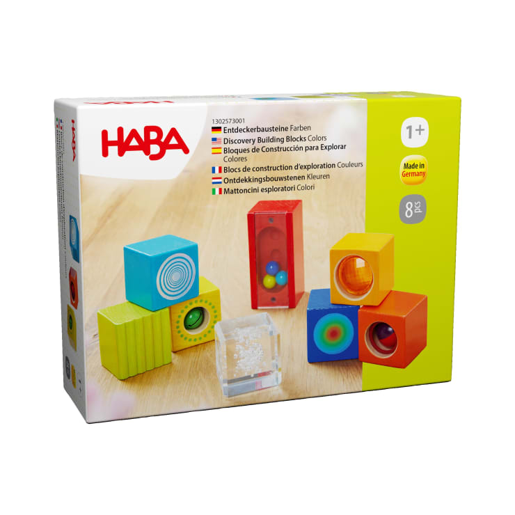 Eine Schachtel mit HABA Discovery Building Blocks Colors für Kinder ab 1 Jahr, die auf der Vorderseite bunte Spielbausteine mit verschiedenen Funktionen wie Spiegeln und Kugeln zeigt. Die Schachtel hebt hervor, dass sie in Deutschland hergestellt wird und 8 Teile enthält.