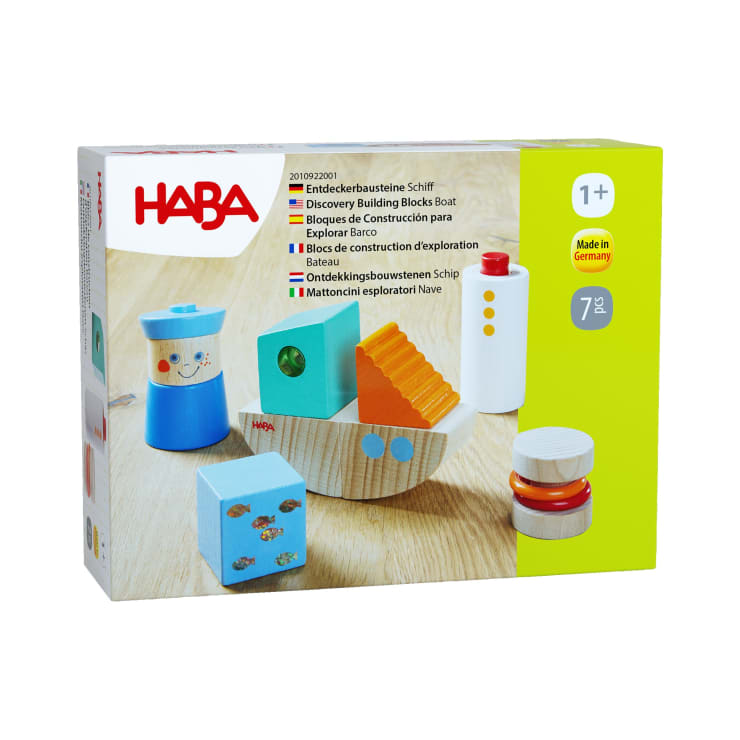Eine Schachtel mit HABA Discovery Building Blocks Boat für Kinder ab 1 Jahr. Die Schachtel zeigt bunte Holzklötze in Form eines Bootes und andere Objekte. Die Verpackung hebt die Funktionen und Altersempfehlungen hervor.