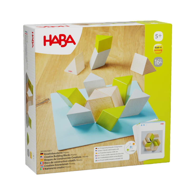 Eine HABA-Kreativ-Bausteine-Prismen-Spielzeugkiste, die hölzerne und grüne Prismenblöcke auf einer hölzernen Oberfläche zeigt. Auf der Schachtel ist angegeben, dass sie für Kinder ab 5 Jahren geeignet ist und 16 Teile enthält.