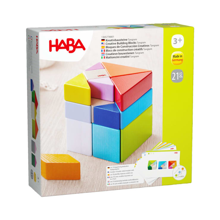 Eine Schachtel HABA-Kreativ-Bausteine Tangram für Kinder ab 3 Jahren mit bunten Holzklötzen, die in einem Quadrat angeordnet sind, und Produktinformationen in mehreren Sprachen auf der Verpackung.