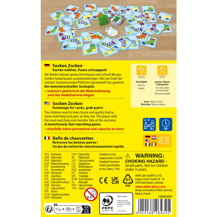 Die Rückseite der Spielschachtel zeigt verschiedene Komponenten des Socken Zocken-Kartenspiels, darunter Karten mit Socken-Illustrationen, Spielanleitungen in mehreren Sprachen und Sicherheitshinweise für kleine Kinder.
