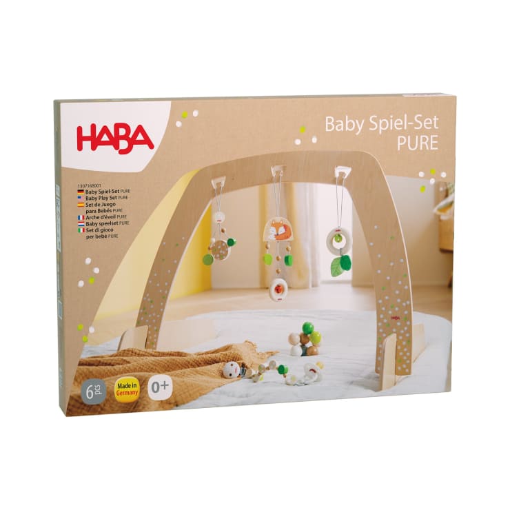 Abgebildet ist eine Schachtel mit dem HABA Baby Spiel-Set PURE. Auf der Verpackung ist ein hölzerner Spielbogen mit hängenden Spielzeugen abgebildet. Das Set ist für Kinder ab 0 Monaten geeignet und wird in Deutschland hergestellt.