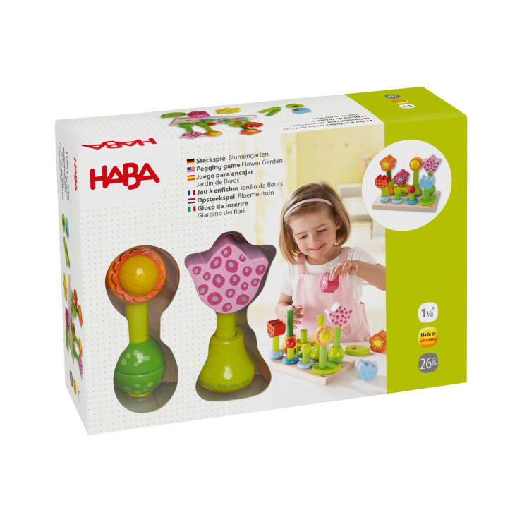 Abgebildet ist ein verpacktes HABA Steckspiel Blumengarten Spielzeugset. Auf der Vorderseite der Schachtel sind blumenförmige Teile und Fotos eines jungen Mädchens abgebildet, das mit dem Spielzeug spielt. Auf der Verpackung steht, dass es für Kinder ab 1 Jahr geeignet ist.