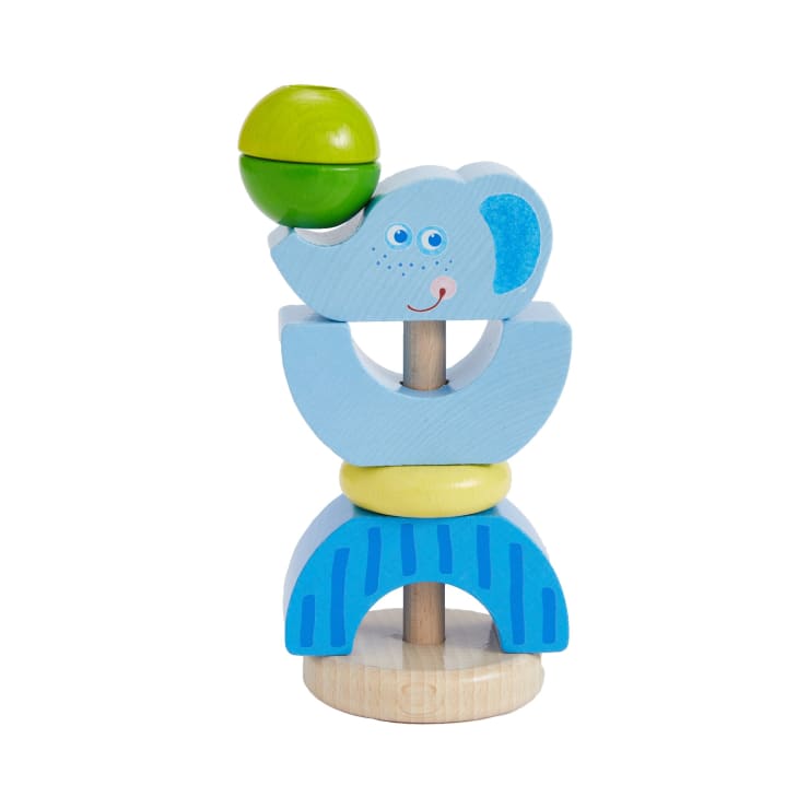 Ein hölzernes Stapelspielzeug in Form eines Elefanten mit blauen und gelben Teilen, einem grünen Ball als Rüssel und einem aufgemalten Gesicht mit lächelndem Ausdruck. Der Sockel ist aus Naturholz.