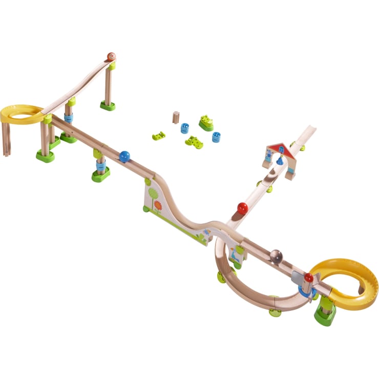 Ein Holzmurmelbahn-Spielzeugset mit gewundenen Bahnen, Schleifen, farbigen Holzkugeln, kleinen Brücken, Rampen und einem Teil in Form eines Hauses, angeordnet auf einem weißen Hintergrund.