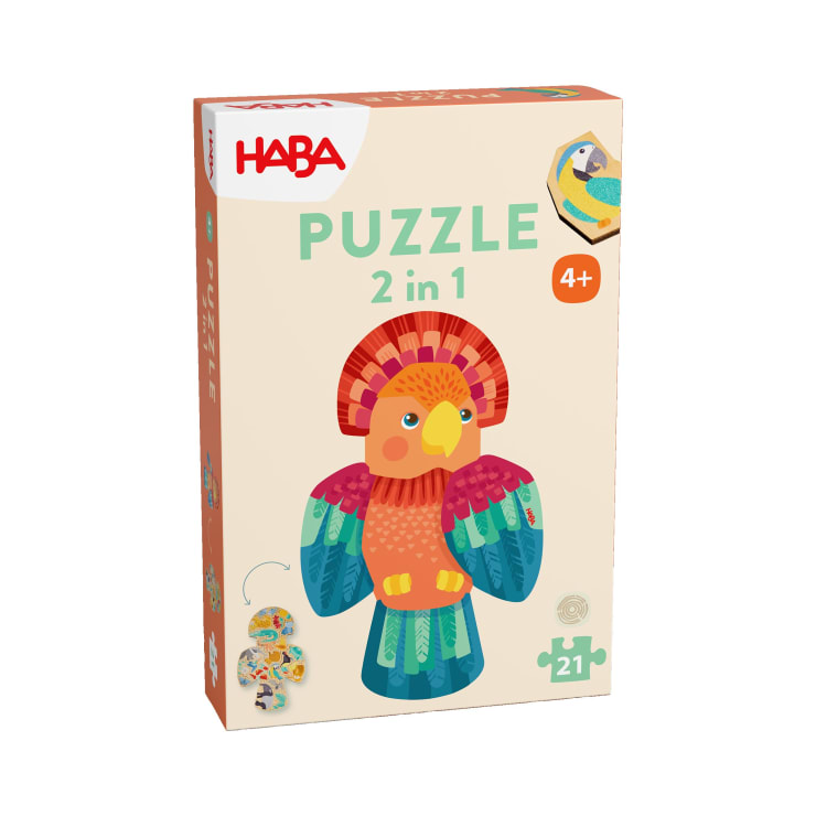 Eine rechteckige Puzzleschachtel mit HABA und PUZZLE 2 in 1 auf der Vorderseite, die eine Illustration eines bunten Vogels und eine 4+ Altersangabe zeigt. Die Schachtel enthält 21 Teile und zeigt ein kleines Bild eines zusammengesetzten Puzzles.