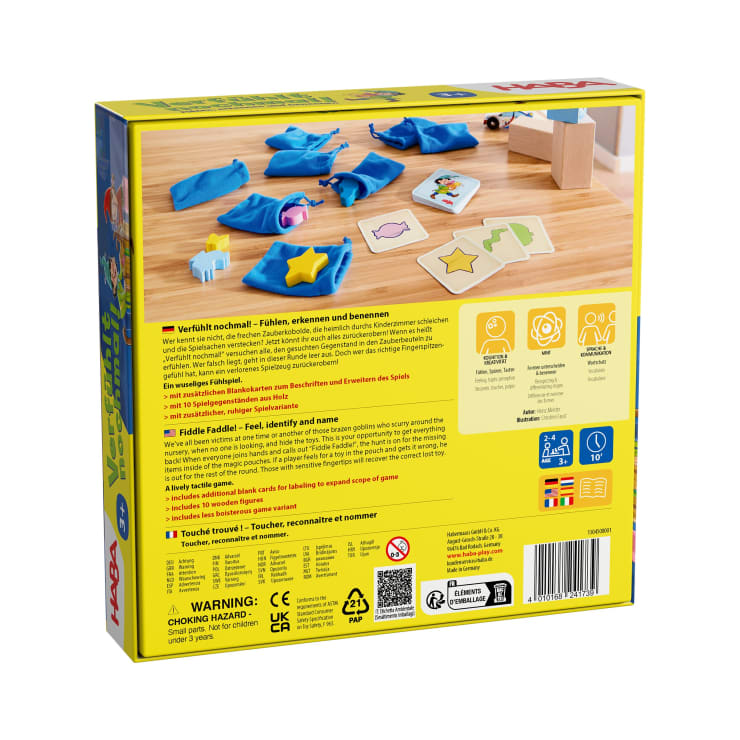 Ein taktiles Kinderspiel mit Holzfiguren, blauen Stofftaschen, illustrierten Karten, einer Anleitung und Würfeln auf einem Tisch. Mehrsprachige Spielbeschreibungen und Warnhinweise sind auf der Rückseite der Schachtel abgedruckt.