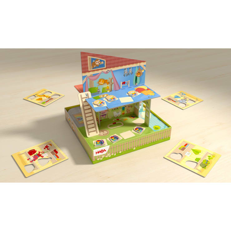 Ein farbenfrohes HABA-Brettspiel in Form eines Hauses mit Hof, mit Tier- und Objektplättchen, einer Leiter und vier Sets von Puzzleteilen auf jeder Seite des Spiels, alles auf einer hellen Holzoberfläche.