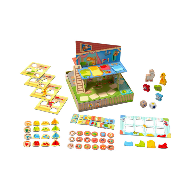 Ein Brettspiel für Kinder mit einem 3D-Haus, Tier- und Charakterfiguren, mehreren Spielbrettern, kreisförmigen Spielsteinen, farbigen Spielfiguren und zwei Würfeln, die alle auf einem weißen Hintergrund angeordnet sind.