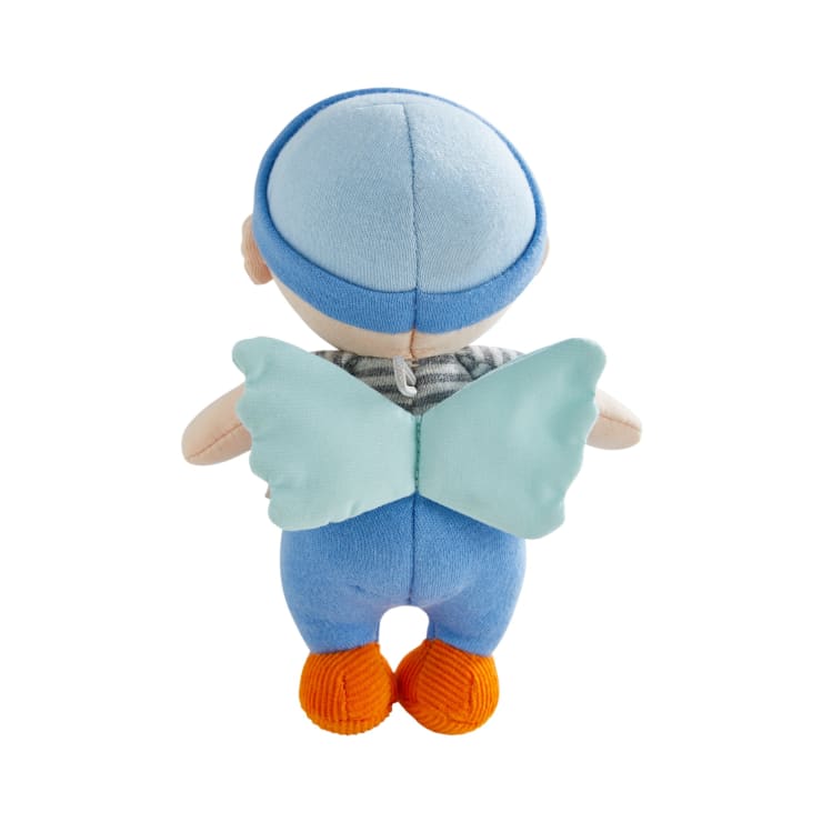 Eine von hinten gezeigte Plüschpuppe, die einen blauen Hut, eine blaue Hose, ein gestreiftes Hemd, orangefarbene Schuhe und hellblaue Stoff-Flügel trägt. Die Puppe ist vor einem weißen Hintergrund fotografiert.