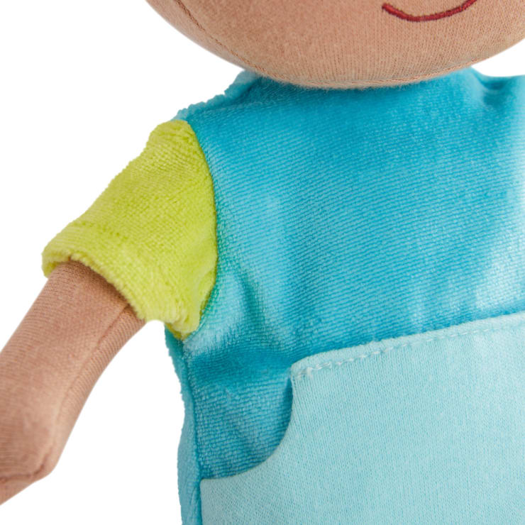 Nahaufnahme einer Stoffpuppe, die ein hellblaues Outfit mit einer Tasche und einem gelben kurzärmeligen Hemd darunter trägt. Nur ein Teil des Gesichts und des Oberkörpers der Puppe sind sichtbar.