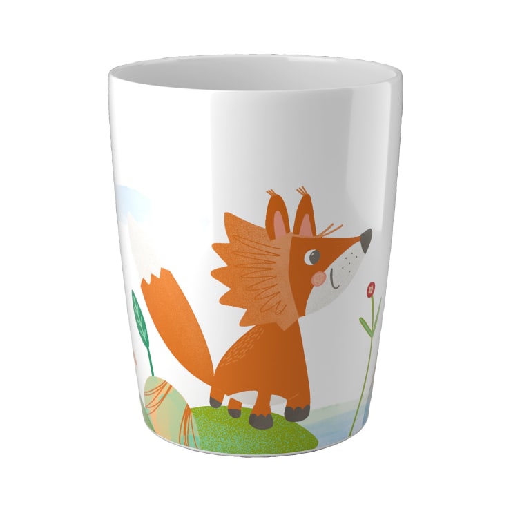 Eine weiße Keramiktasse mit der Illustration eines orangefarbenen Cartoon-Fuchses, der auf grünem Gras mit einer Blume und blauem Himmel im Hintergrund steht.