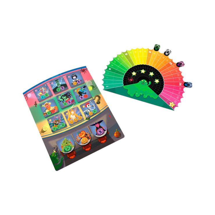 Ein farbenfrohes Brettspiel mit einem rechteckigen Spielbrett mit Figurenillustrationen und einer halbrunden Punktetafel mit Zahlen, Symbolen und einer grünen Kreatur in der Mitte.