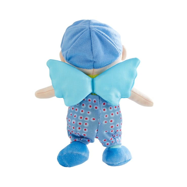 Eine von hinten gezeigte Plüschpuppe mit blauer, kreisförmig gemusterter Kleidung, blauen Schuhen, einem blauen Hut und hellblauen, auf dem Rücken befestigten Stoffflügeln vor einem weißen Hintergrund.