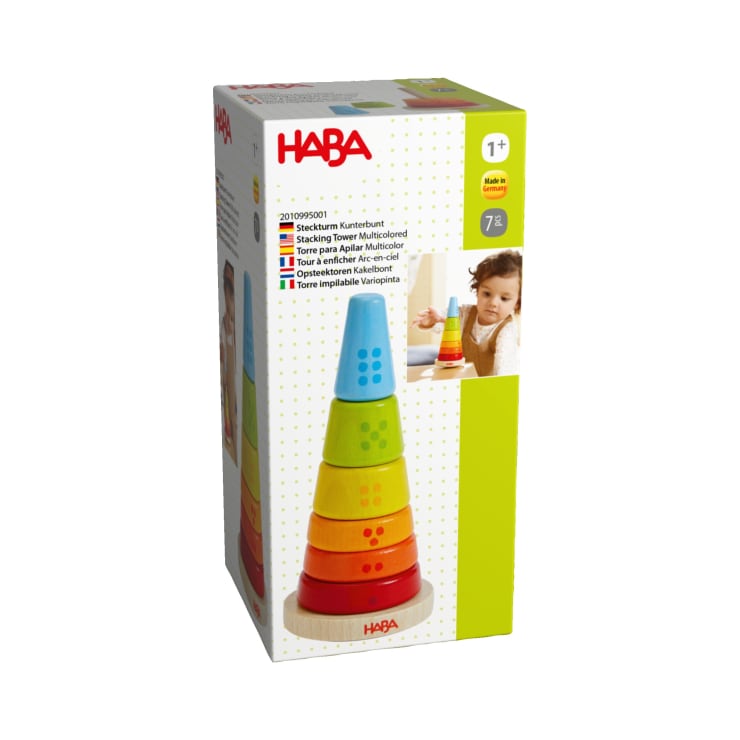 Eine rechteckige Schachtel mit dem HABA-Branding enthält einen Stapelturm mit bunten, abgestuften Ringen. Die Verpackung zeigt ein Bild des zusammengebauten Spielzeugs und ein Foto eines kleinen Kindes, das damit spielt. Geeignet für Kinder ab 1 Jahr.