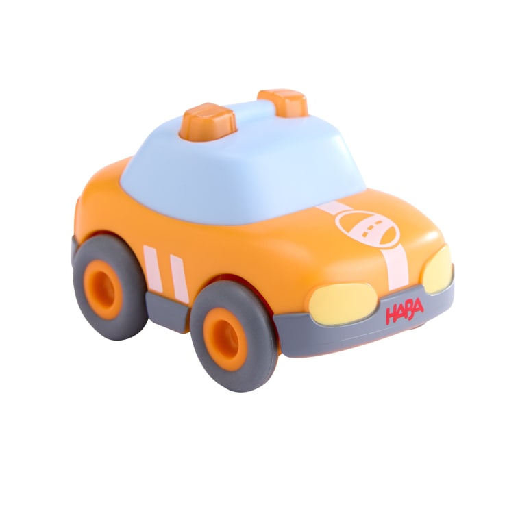 Ein kleines orange-graues Spielzeugauto mit einem hellblauen Dach, gelben Scheinwerfern, zwei orangefarbenen Dachlampen und dem Wort HABA auf der vorderen Stoßstange. Das Auto ist auf einem weißen Hintergrund abgebildet.