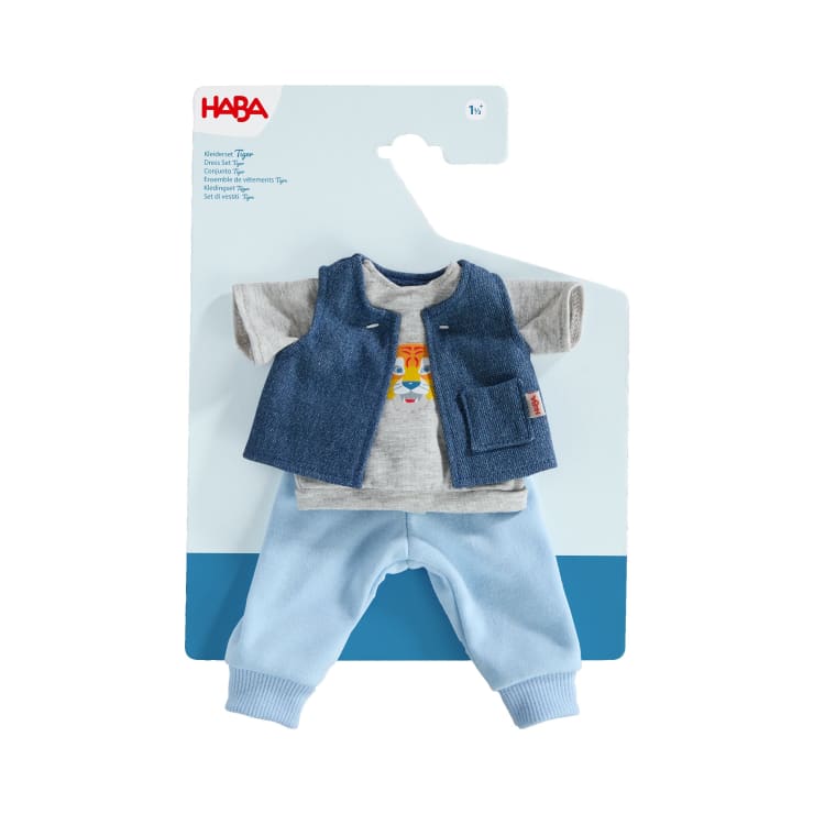Dreiteiliges Puppen-Outfit-Set auf einer Display-Karte, bestehend aus einem grauen T-Shirt mit Tiermotiv, einer blauen Jeansweste mit Tasche und einer hellblauen Hose. Das HABA-Markenlogo ist oben auf der Verpackung zu sehen.