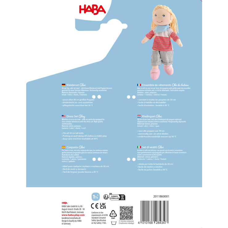 Ein Produktetikett für ein HABA-Puppenkleider-Set ist in mehreren Sprachen abgebildet. Das Etikett zeigt ein Foto einer blonden Puppe in einem gestreiften Oberteil und einer blauen Hose, darunter stehen Produkt- und Sicherheitsinformationen.