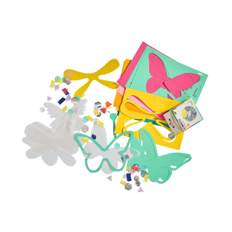 Buntes Bastelmaterial wie Schaumstoffplatten, Schmetterlings- und Blumenformen, Chenillestiele, kleine Papierquadrate und eine Bastelanleitung auf weißem Hintergrund.