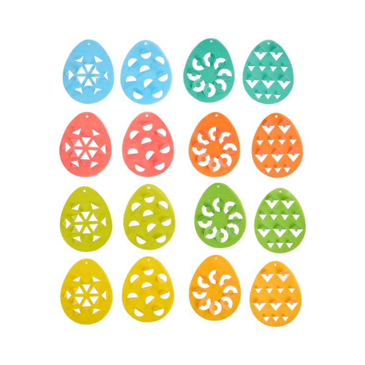 Sechzehn bunte, eiförmige Ornamente mit verschiedenen ausgeschnittenen geometrischen Mustern sind in einem 4x4-Raster angeordnet. Die Ornamente sind blau, rot, grün und gelb. Jedes Ornament hat ein kleines Loch an der Oberseite.