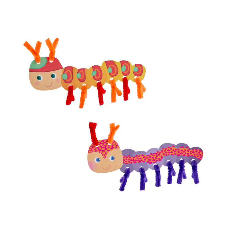 Zwei Cartoon-Raupen aus buntem Papier und Pfeifenreinigern; eine Raupe ist orange und grün mit orangefarbenen Beinen, die andere ist lila und rosa mit lila Beinen, beide haben lächelnde Gesichter und orange Fühler.