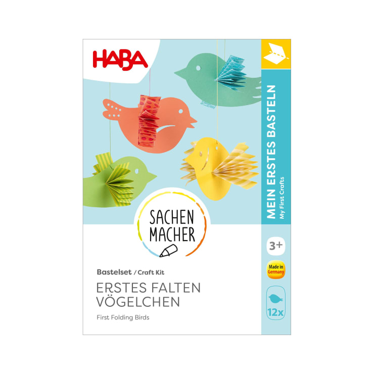 Eine Bastelpackung mit der Aufschrift HABA zeigt bunte Papiervögel, die an Schnüren hängen. Der Text beinhaltet Erstes Falten Vögelchen und My First Crafts und weist darauf hin, dass es für Kinder ab 3 Jahren geeignet ist und in Deutschland hergestellt wird.