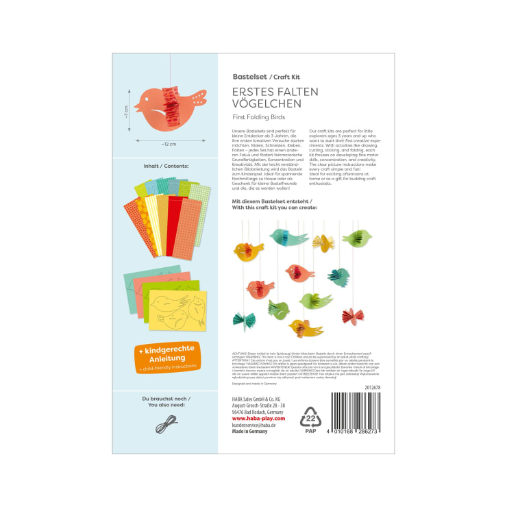 Rückseite einer Bastelpackung mit Papierbögen, illustrierten Anleitungen und fertigen bunten Papiervögeln, die an Schnüren hängen. Der Text ist auf Deutsch und Englisch und beschreibt den Inhalt des Sets und die Bastelschritte.