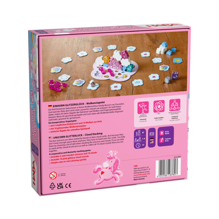 Eine rosafarbene rechteckige Schachtel mit dem Brettspiel Einhorn-Glitterluck-Wolkenstapeln. Auf der Rückseite sind Spielfiguren, Aufbau, Anleitung in Deutsch und Englisch sowie Symbole für Alters- und Spielerempfehlungen abgebildet.