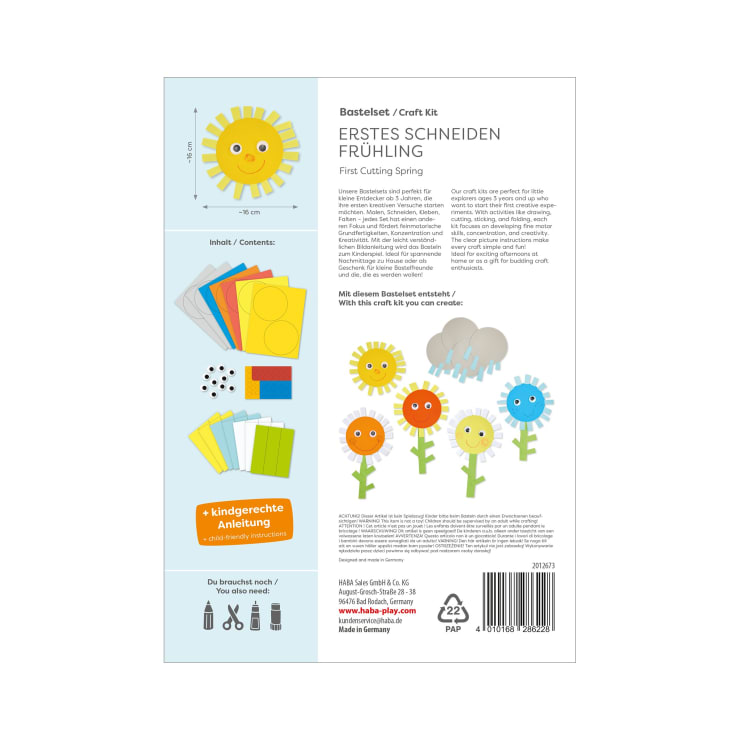 Eine Bastelpackung mit der Aufschrift Erstes Schneiden Frühling zeigt den Inhalt, darunter farbiges Papier, Klebstoff und Glupschaugen. Illustrierte Blumen und eine Sonne sind neben der Anleitung in Deutsch und Englisch abgebildet.