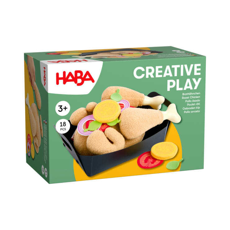 Eine Schachtel mit dem HABA Creative Play Spielzeugset für Kinder ab 3 Jahren mit 18 Teilen, darunter Brathähnchenkeulen aus Plüsch, Zitronenscheiben, Salat und Tomaten, die auf der Verpackung in einem schwarzen Tablett präsentiert werden.