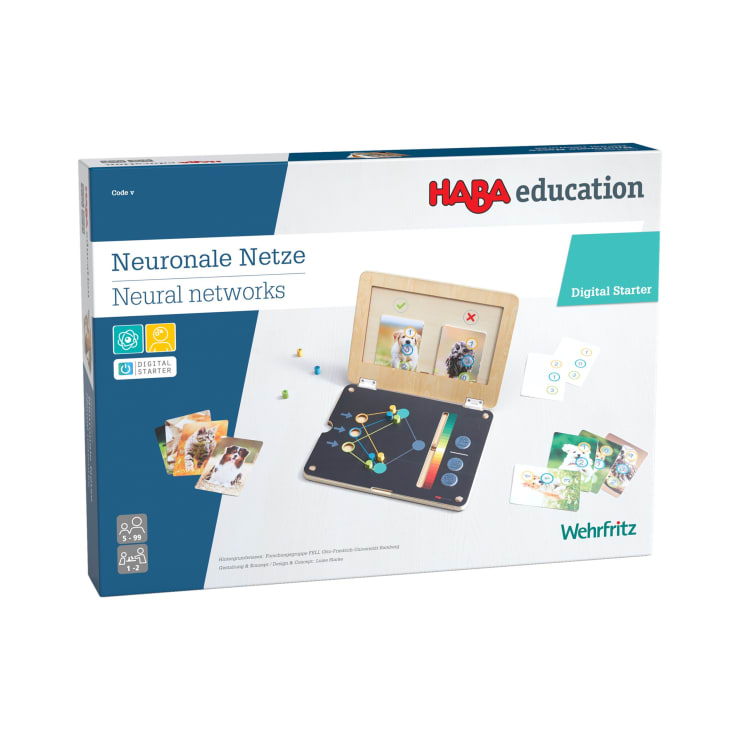 Eine Schachtel mit der Aufschrift "HABA education Neuronale Netze Neural networks Digital Starter" zeigt Lernmaterialien zum Thema neuronale Netze, darunter Bildkarten, ein Tablet und einen Holzständer. Der Markenname Wehrfritz ist sichtbar.