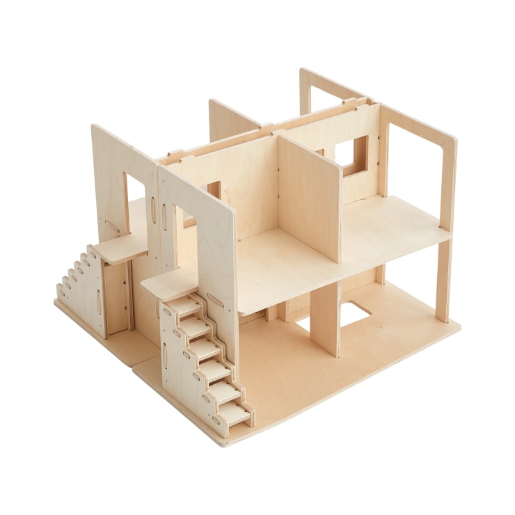 Ein Puppenhaus aus Holz mit zwei Etagen, offenen Seiten und mehreren Räumen. Es verfügt über zwei Treppen und mehrere Türen, mit unbehandeltem Holz und einem minimalistischen Design.