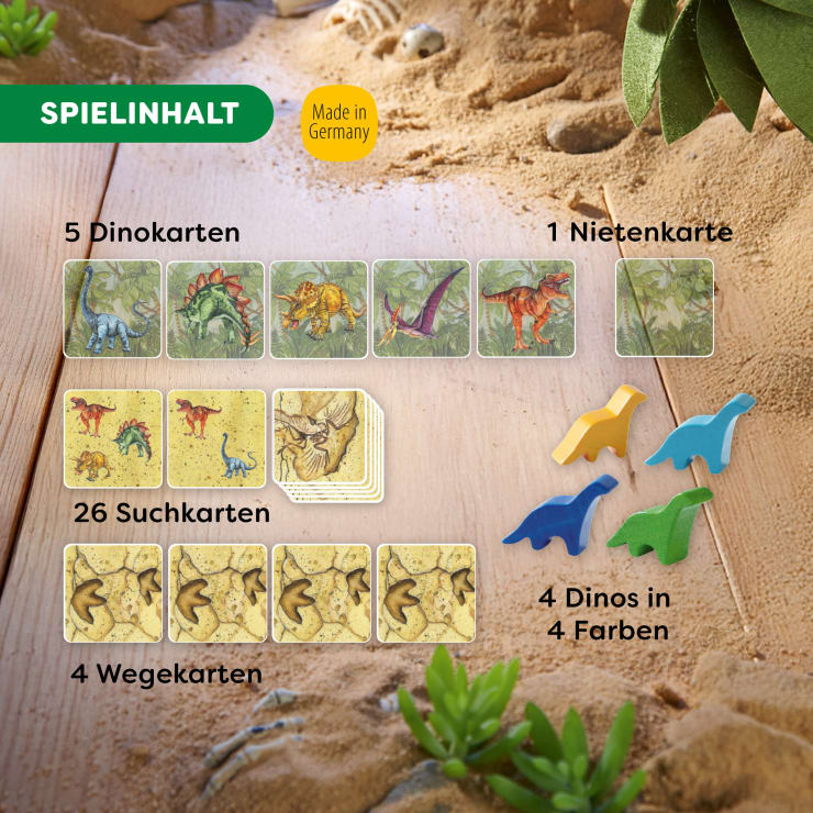 Karten und hölzerne Dinosaurierteile auf Sand angeordnet. Das Layout enthält beschriftete Abschnitte: 5 Dinosaurierkarten, 1 Blindgängerkarte, 26 Suchkarten, 4 Wegkarten und 4 Dinos in 4 Farben. Grünes SPIELINHALT-Etikett oben links.