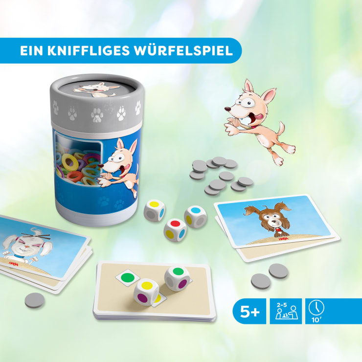 Ein Würfelspiel für Kinder mit bunten Würfeln, runden grauen Spielsteinen, illustrierten Karten mit Tieren und einem zylindrischen Behälter mit einer Hundeillustration. Der Text auf Deutsch lautet: Ein messerscharfes Würfelspiel. Für Kinder ab 5 Jahren.