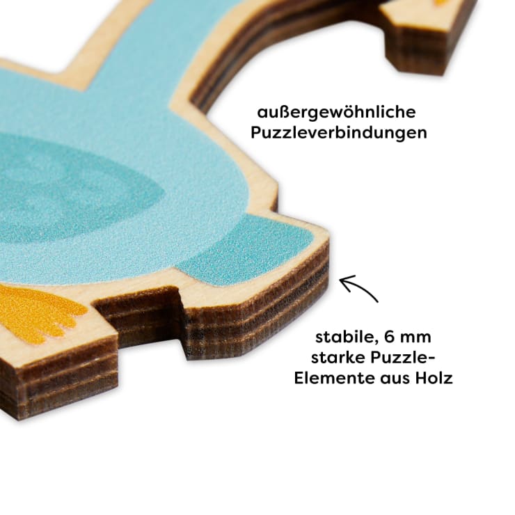 Nahaufnahme eines Holzpuzzleteils mit ineinandergreifenden Kanten. Text in deutscher Sprache weist auf außergewöhnliche Puzzleverbindungen und stabile 6 mm dicke Puzzleelemente aus Holz hin, die mit Pfeilen auf Merkmale hinweisen.