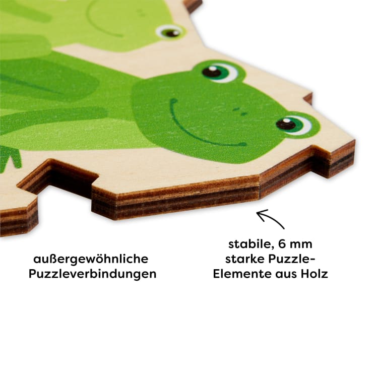 Nahaufnahme eines Holzpuzzleteils mit einem Cartoon-Frosch. Ein Text in deutscher Sprache weist auf die ungewöhnlichen Puzzleverbindungen hin und erklärt, dass die Puzzleteile stabil und 6 mm dick sind.
