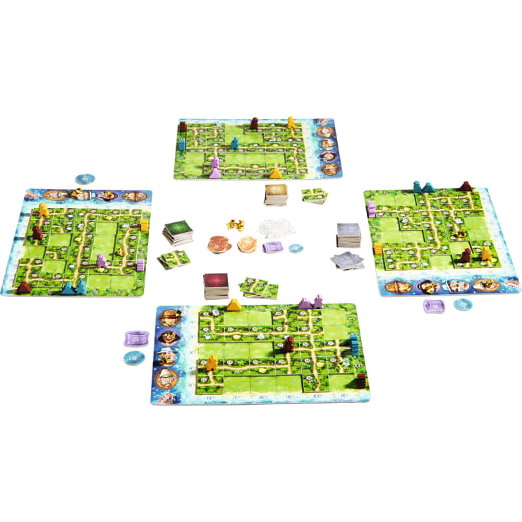 Vier bunte Spielertafeln und eine zentrale Tafel werden für ein Brettspiel aufgestellt. Verschiedene Karten, Spielsteine und Holzfiguren sind zwischen den Brettern angeordnet und bereit zum Spielen. Die Spielbretter sind mit Wegen und illustriertem Terrain versehen.