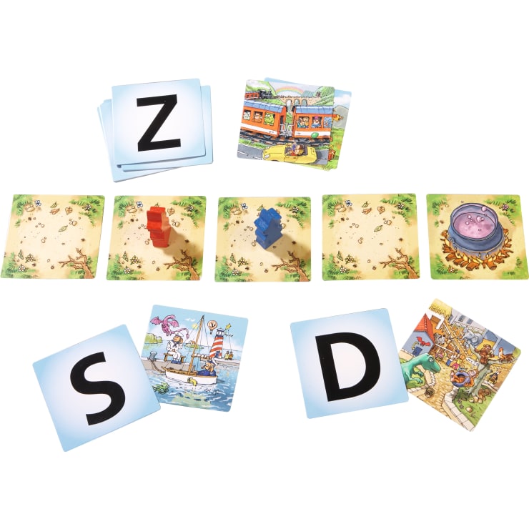 Ein Tischspiel mit drei Buchstabenkarten (Z, S, D), illustrierten Szenenkarten, vier quadratischen Plättchen mit Spielsteinen auf zwei von ihnen und einer Karte mit einer Kesselillustration ganz rechts.