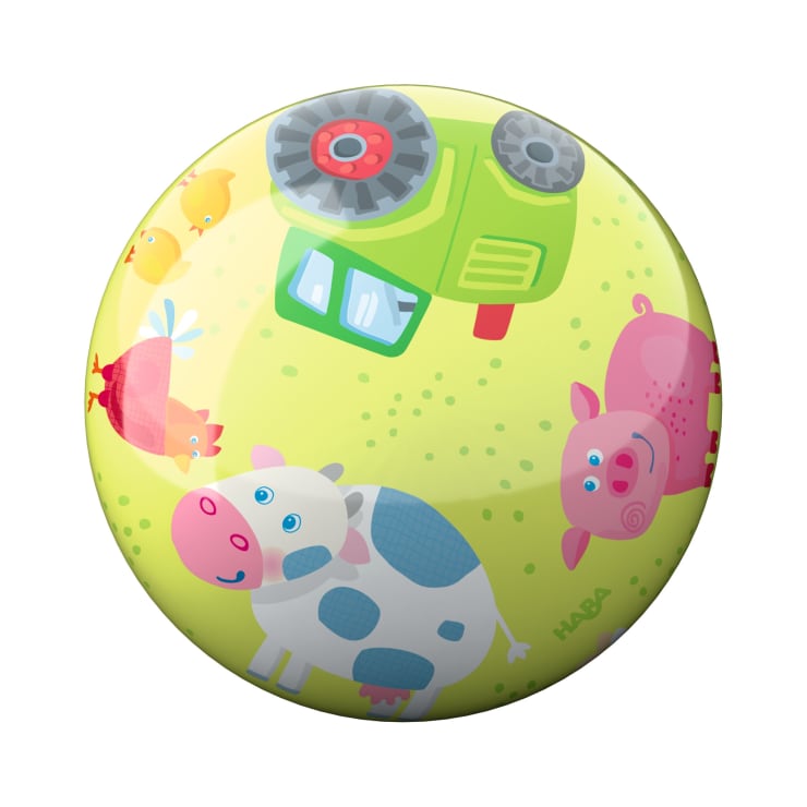 Auf einem runden, gelben Ball sind eine Kuh, ein Schwein, ein Huhn, Küken und ein grüner Traktor auf einem grasbewachsenen Hintergrund abgebildet. Das Wort HABA ist neben dem Schwein aufgedruckt.