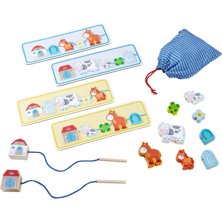 Ein Kinder-Schnürspielset mit Spielsteinen in Form von Tieren und Häusern, vier illustrierten Aktivitätskarten, einem blau gestreiften Beutel mit Kordelzug und zwei Schnürsenkeln mit blauen Schnüren, alles auf weißem Hintergrund.