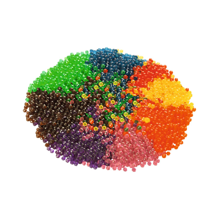 Ein Bündel kleiner, runder Perlen, die nach Farben geordnet sind, darunter grün, blau, orange, gelb, braun, lila, rosa und rot, auf weißem Hintergrund.