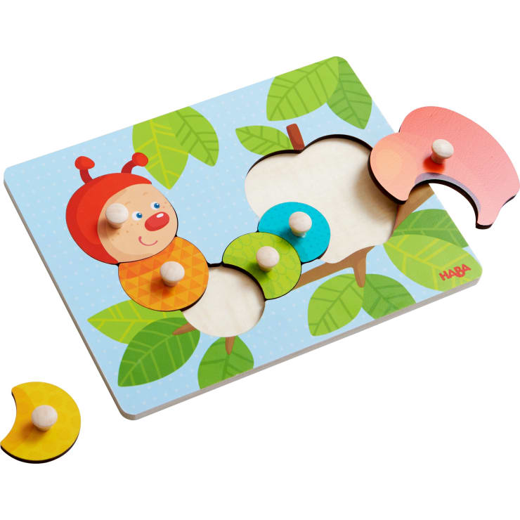 Ein Holzpuzzle mit einer Cartoon-Raupe und einem Apfel, mit drei abnehmbaren Teilen, die für eine einfache Handhabung mit Knöpfen versehen sind. Der Hintergrund des Puzzles zeigt grüne Blätter und einen blauen Himmel.