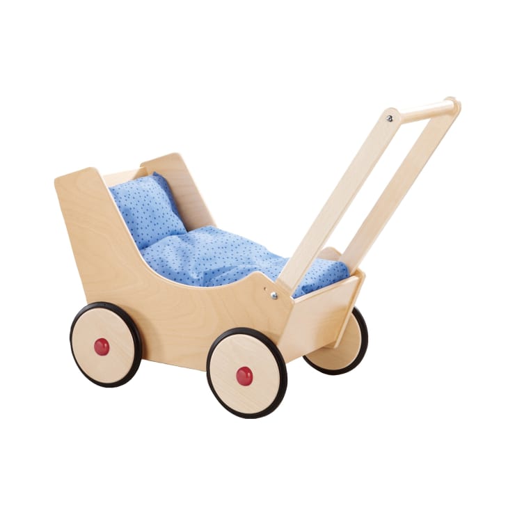 Ein Spielzeugkinderwagen aus Holz mit vier schwarzen Rädern, einem einfachen Griff und einem blauen gepunkteten Kissen im Inneren. Der Kinderwagen ist leer und steht vor einem schlichten weißen Hintergrund.